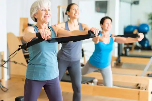 Toning Arms After 60: Empowering Womens Fitness Through Effective Weight Training 2 older woman doing weight training Salisbury and resistance in the gym to tone upper arms