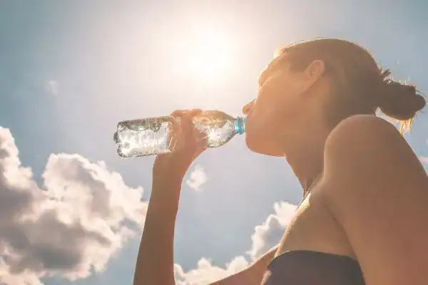 Hydration: The Secret Ingredient for a Toned Stomach and Enhanced Fitness 3 Image of woman drinking water to hydrate Salisbury after run.