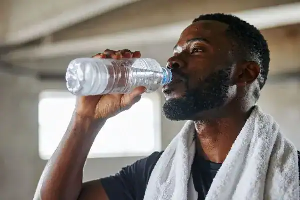 Hydration: The Secret Ingredient for a Toned Stomach and Enhanced Fitness 1 Image of man drinking water to improve hydration Salisbury after work out.